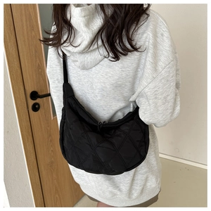 Vista posteriore di una modella con borsa a tracolla trapuntata nera a forma di mezzaluna