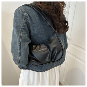 Détail de la texture plissée noire et de l'étiquette Fashion sur ce sac hobo en similicuir