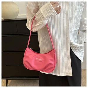 Détail du sac baguette rose plissé avec le logo métallique FASHION & BAG sur l'avant