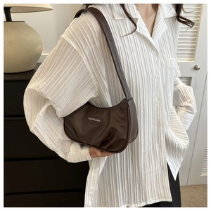 Détail du sac demi-lune plissé marron foncé en cuir PU souple avec plaque en métal