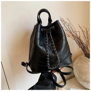 Detail of black quilted bucket bag featuring a gold chain drawstring and PU leather texture