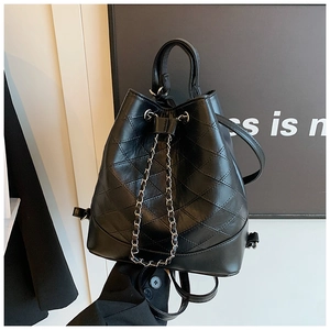 Detail of black quilted bucket bag featuring silver metal chain drawstring and PU leather