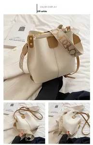 Détail du sac seau blanc crème avec large bandoulière jacquard et sangle en cuir