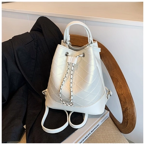 Detail of white quilted drawstring bucket bag with silver chain straps and pearl finish
