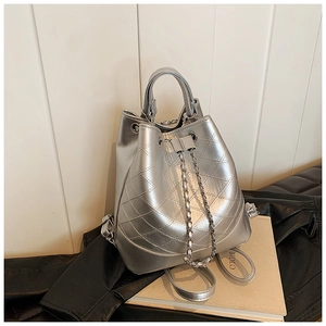 Detail of silver quilted bucket bag with metallic finish and chain drawstring closure