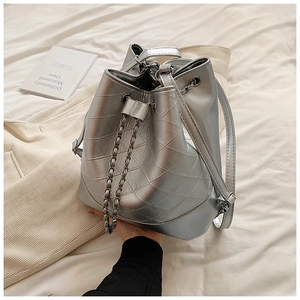 Detail of silver bucket bag showing diamond quilted pattern and metal chain drawstring