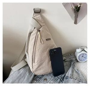 Comparaison de taille du sac de poitrine beige avec un smartphone sur du denim
