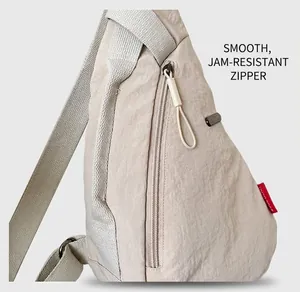 Détail de la fermeture éclair fluide et du tissu en nylon de ce sac bandoulière beige