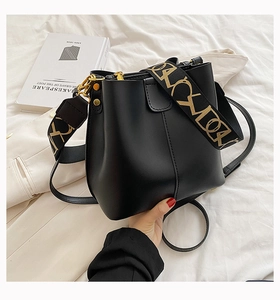 Détail du sac seau noir avec bandoulière jacquard vintage et finitions dorées