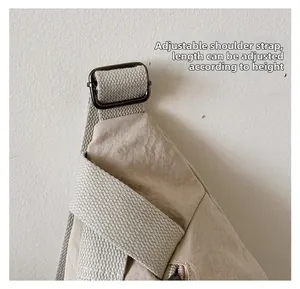 Détail de la bandoulière réglable avec boucle en métal sur sac de poitrine en nylon