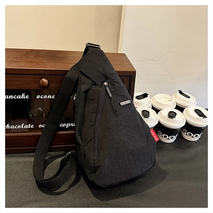 Détail du sac bandoulière noir en nylon avec logo EVOL GEAR et poche zippée verticale