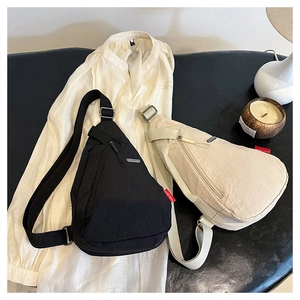 Vue détaillée des sacs de poitrine en nylon noir et crème sur une chemise blanche