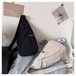 Détail de sacs de poitrine en toile en noir et beige sur une veste en jean