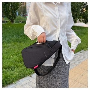 Photo en extérieur d'un sac de poitrine en nylon noir imperméable avec sangle