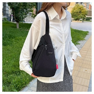 Photo en extérieur du sac de poitrine EVOL GEAR noir porté sur une chemise blanche