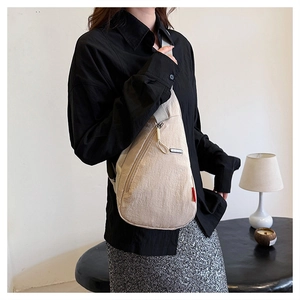 Gros plan détaillé d'un sac de poitrine beige en nylon porté par un mannequin de mode