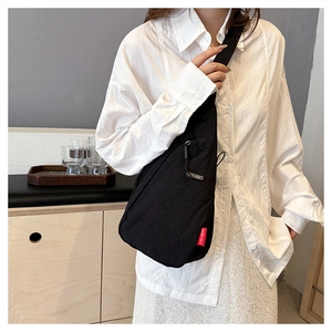 Détail du sac de poitrine en nylon noir avec étiquette rouge EVOL GEAR et bandoulière