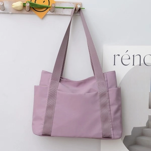 Detail of light purple waterproof nylon tote bag hanging on wall with side pocket
