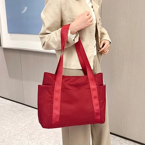 Detail of red nylon tote bag with side pocket and spacious storage for daily commuting