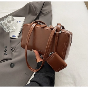Detail of a brown PU leather Boston bag with matching coin purse and silver metal zipper