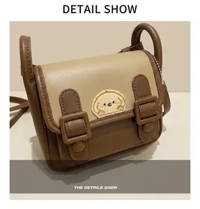 Vue détaillée du sac contrasté avec un joli patch brodé en peluche de chiot jaune vif