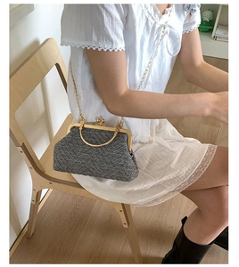 Détail du sac coquille en tweed gris avec bandoulière chaîne dorée et fermoir métal