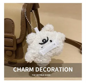 Détail d'une peluche d'ours beige avec masque décoratif sur un sac à main vintage