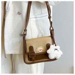 Détail du sac bandoulière rétro bicolore avec broderie chien et breloque étoile en peluche