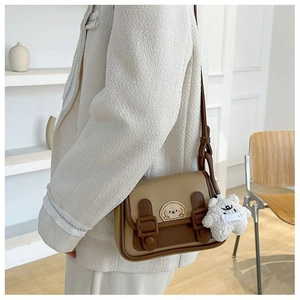 Détail du sac à bandoulière bicolore rétro avec écusson chiot et pendentif étoile