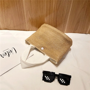 Handwoven straw beach tote bag with white canvas handles for summer vacation and travel
