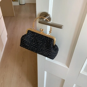 Detail of black sequin shell bag with vintage gold engraved handle and ball clasp
