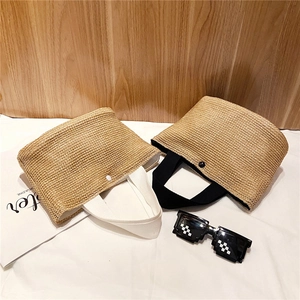 Flat lay of woven straw tote bags with canvas handles and pixel sunglasses on white fabric