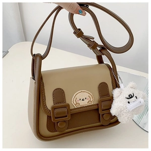 Détail du sac rétro bicolore avec broderie de chiot et adorable porte-clés ours en peluche