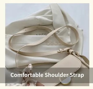 Detail of beige leather shoulder bag featuring a metal buckle and floral silk scarf