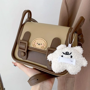 Détail du sac à bandoulière rétro bicolore avec broderie chien et breloque ours en peluche
