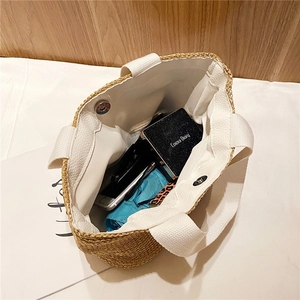 Top view of woven straw tote bag interior showing large capacity and white canvas handles