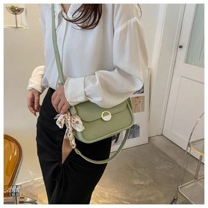 Detail of light green faux leather shoulder bag with floral silk scarf and metal clasp