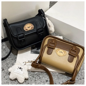 Détail de sacs rétro à rabat avec broderie ours et breloques en peluche