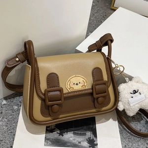 Détail du sac bandoulière bicolore avec broderie chiot et pendentif en peluche blanc