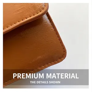 Detailed macro view of the premium leather texture and precise stitching on a brown bag