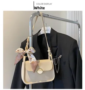 Detail of white PU leather small square bag with floral scarf handle and metal turn lock