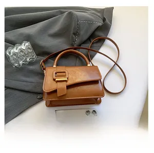 Brown PU leather handbag size comparison with phone showing compact vintage square design