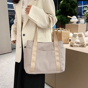 Detail of light beige waterproof nylon tote bag with wide straps and side pockets