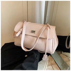 Detail of light pink lychee pattern handbag with silver square twist lock and leather texture