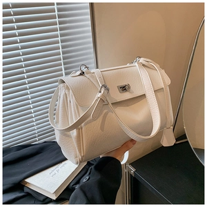 Detail of white lychee leather handbag with silver clasp and side pleats