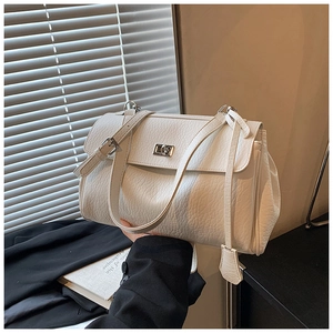 Detail of white lychee leather texture on underarm bag with silver twist lock and strap