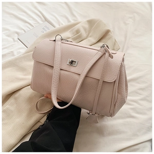 Detail of light pink shoulder bag with pebbled leather texture and silver twist lock closure