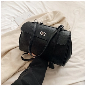 Close-up of black litchi pattern leather bag with elegant silver twist-lock closure