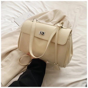 Detail of cream-colored cracked texture shoulder bag with silver metallic twist lock