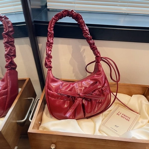 Deep red hobo shoulder bag with large bow and ruffled strap in shiny finish